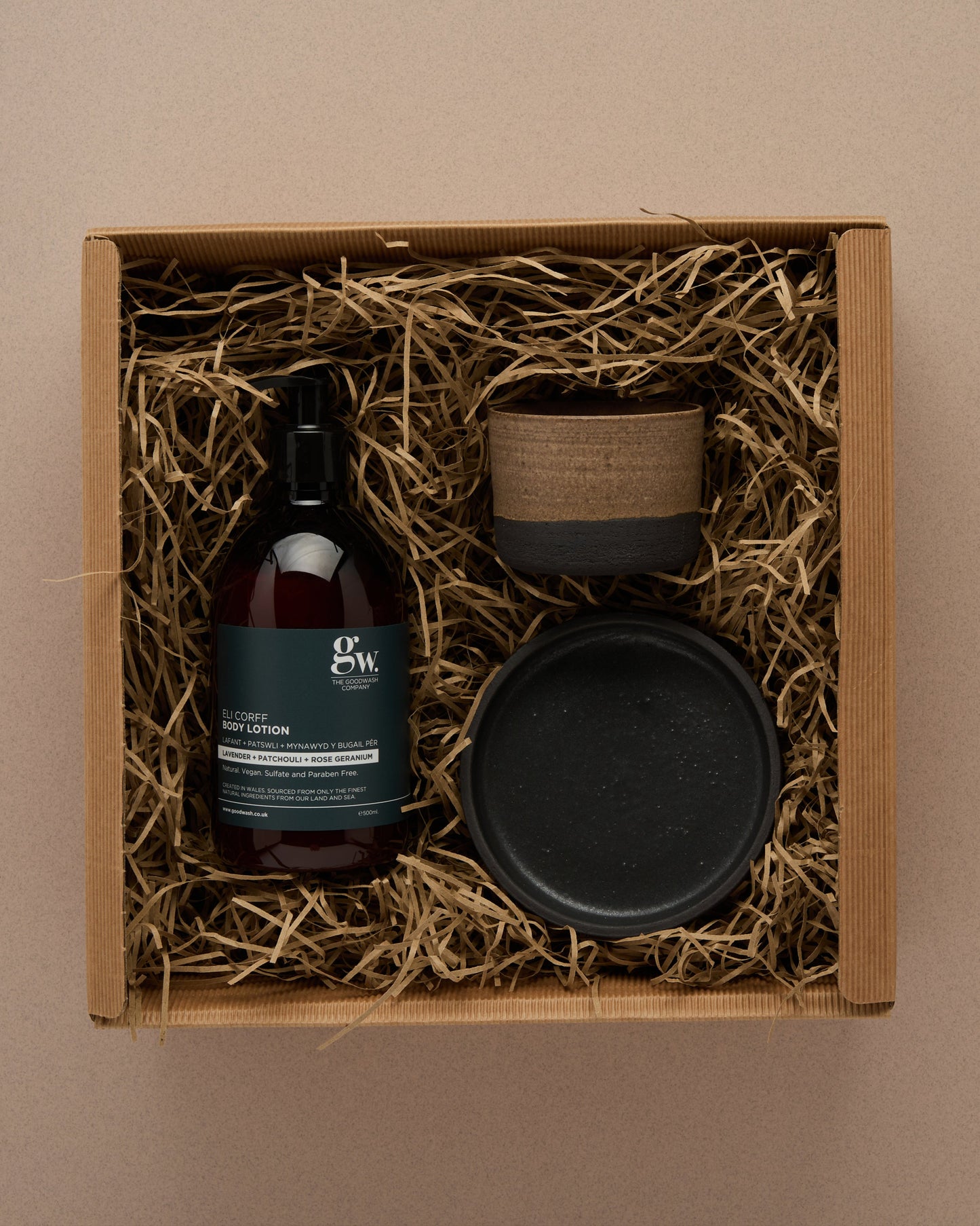 Skincare product set with body cream mug, and plate in a box on a beige background