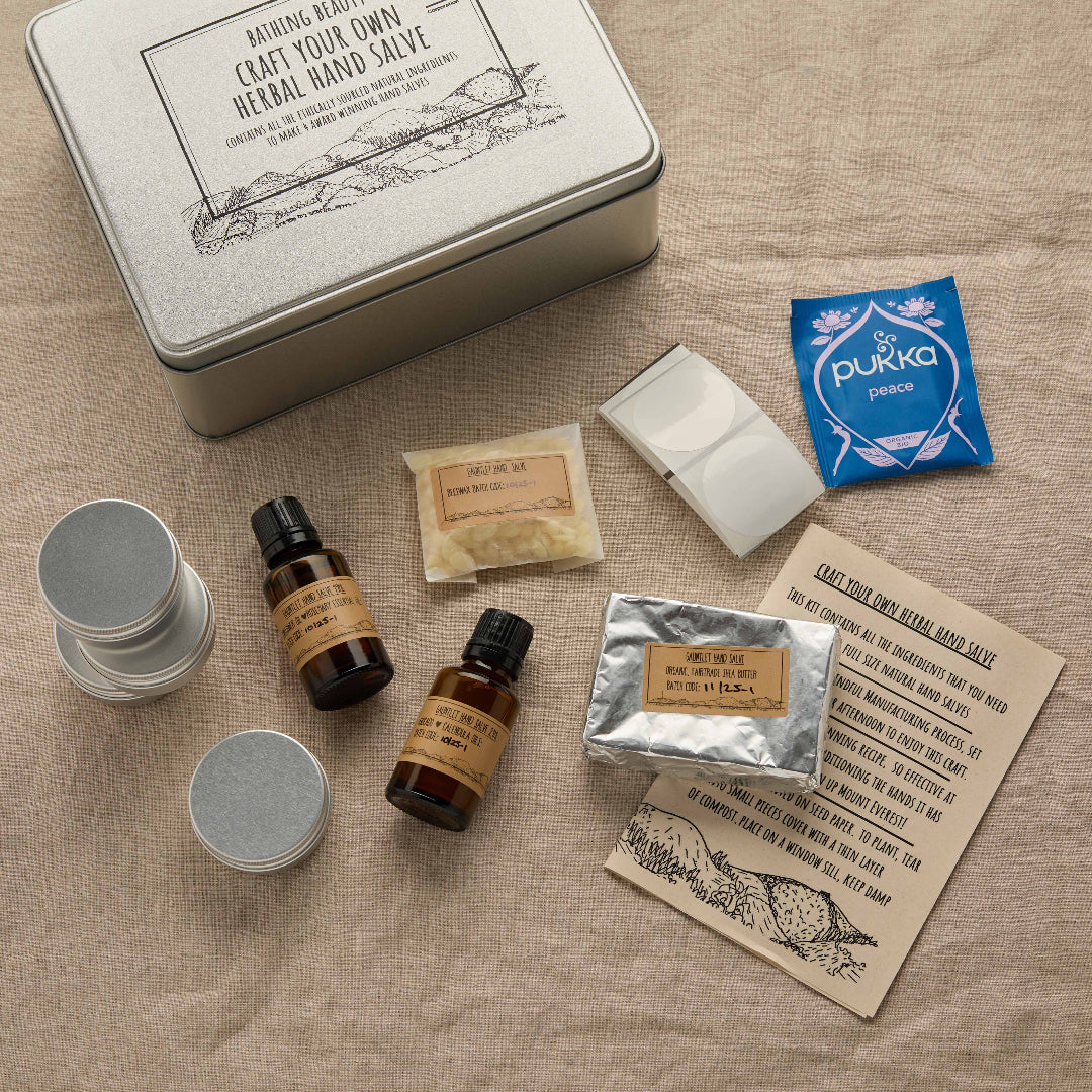 Collection of natural products including bottles, containers, and a card on a textured surface