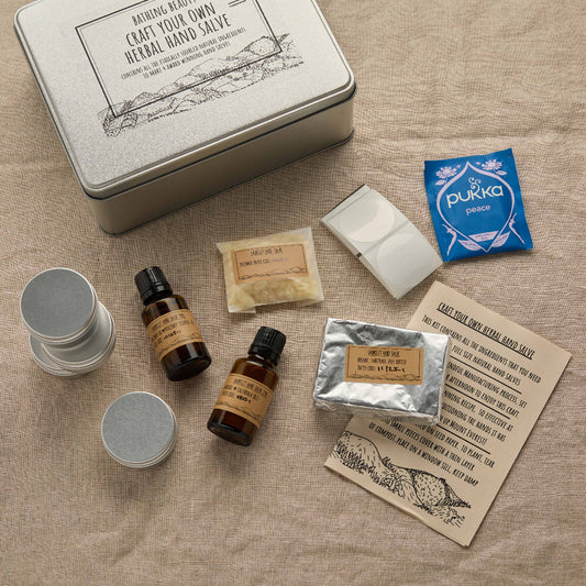 Collection of natural products including bottles, containers, and a card on a textured surface