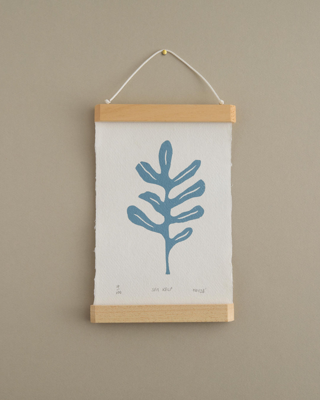 Wall art with a blue leaf design on a beige background