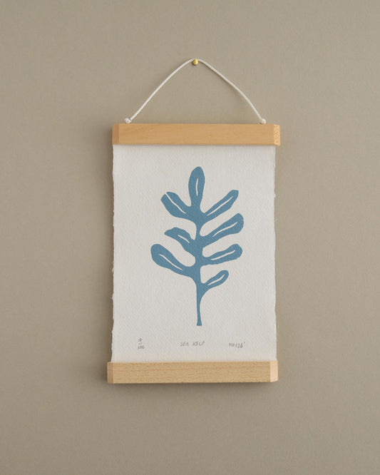 Wall art with a blue leaf design on a beige background